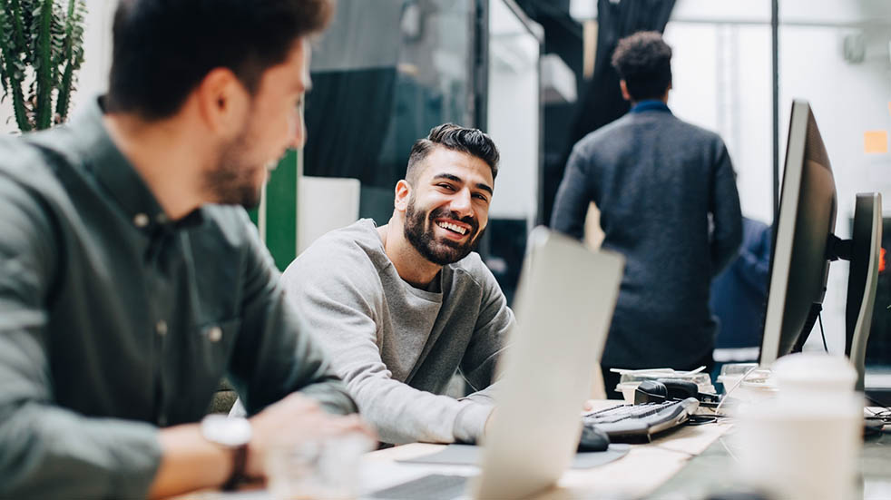 How do you measure happiness at work; men smiling in office